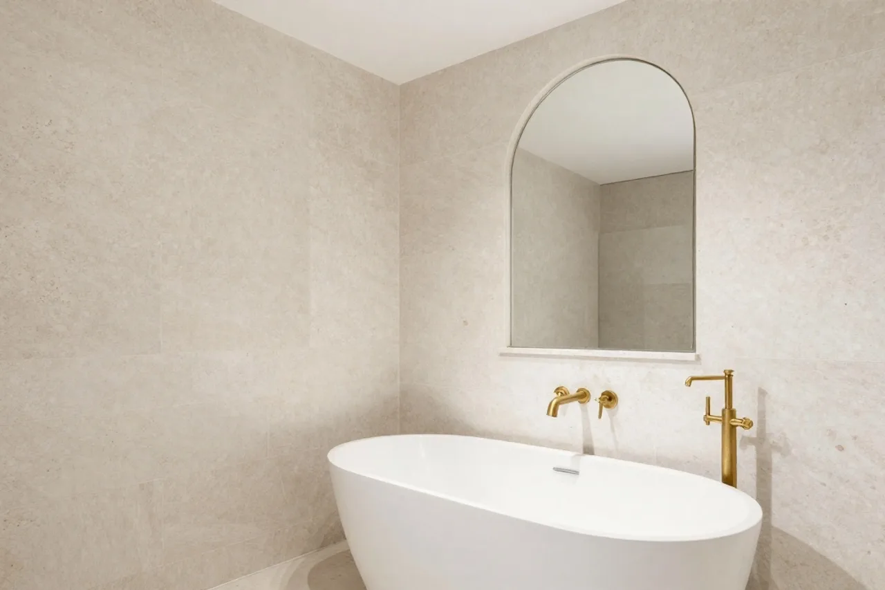 Salle de bain en travertin, baignoire indépendante et robinetterie laiton brossé